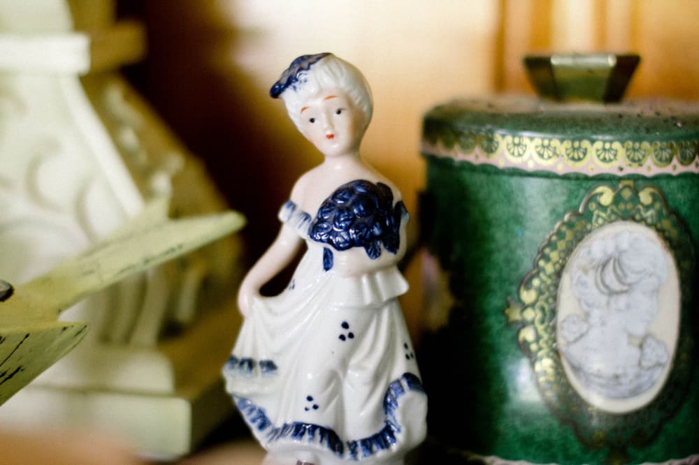 A vintage porcelain-style figure beside decorative objects
