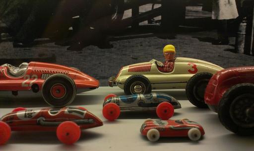 Vintage tin race cars and small toy vehicles in a display
